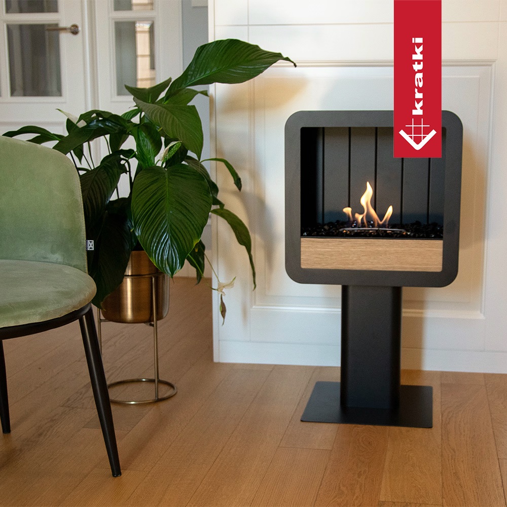 Biokrb TETRA/STAND na oceľovej nohe vedľa zelenej stoličky a rastliny v interiéri s drevenou podlahou